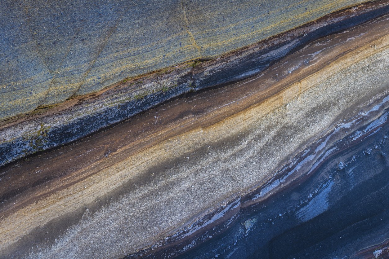 Dipping sedimentary rock layers in cross section, the kind of subsurface structure a seismic survey is designed to image